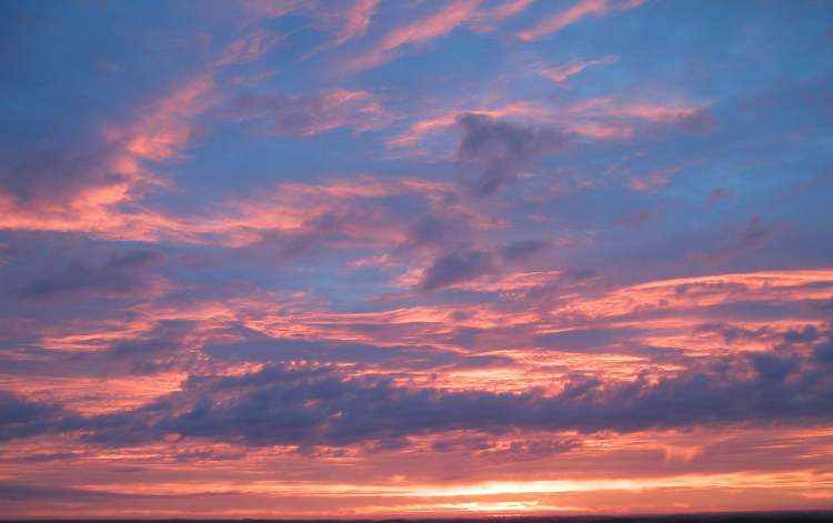 Wolken im rötlichen Sonnenaufgangslicht (Bitte hier klicken um dieses Bild in seiner vollen Größe zu betrachten)