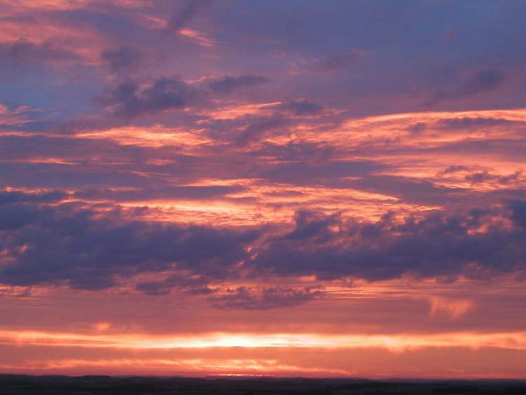 Wolken im roten Sonnenaufgangslicht (Bitte hier klicken um dieses Bild in seiner vollen Größe zu betrachten)