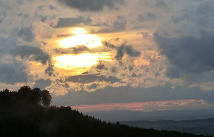 Abendhimmel mit leuchtender Sonne hinter Wolken (Bitte hier klicken um dieses Bild in seiner vollen Größe zu betrachten)