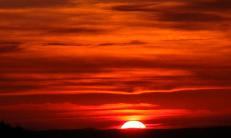 der leuchtende Sonnenuntergang mit Wolken (Bitte hier klicken um dieses Bild in seiner vollen Größe zu betrachten)